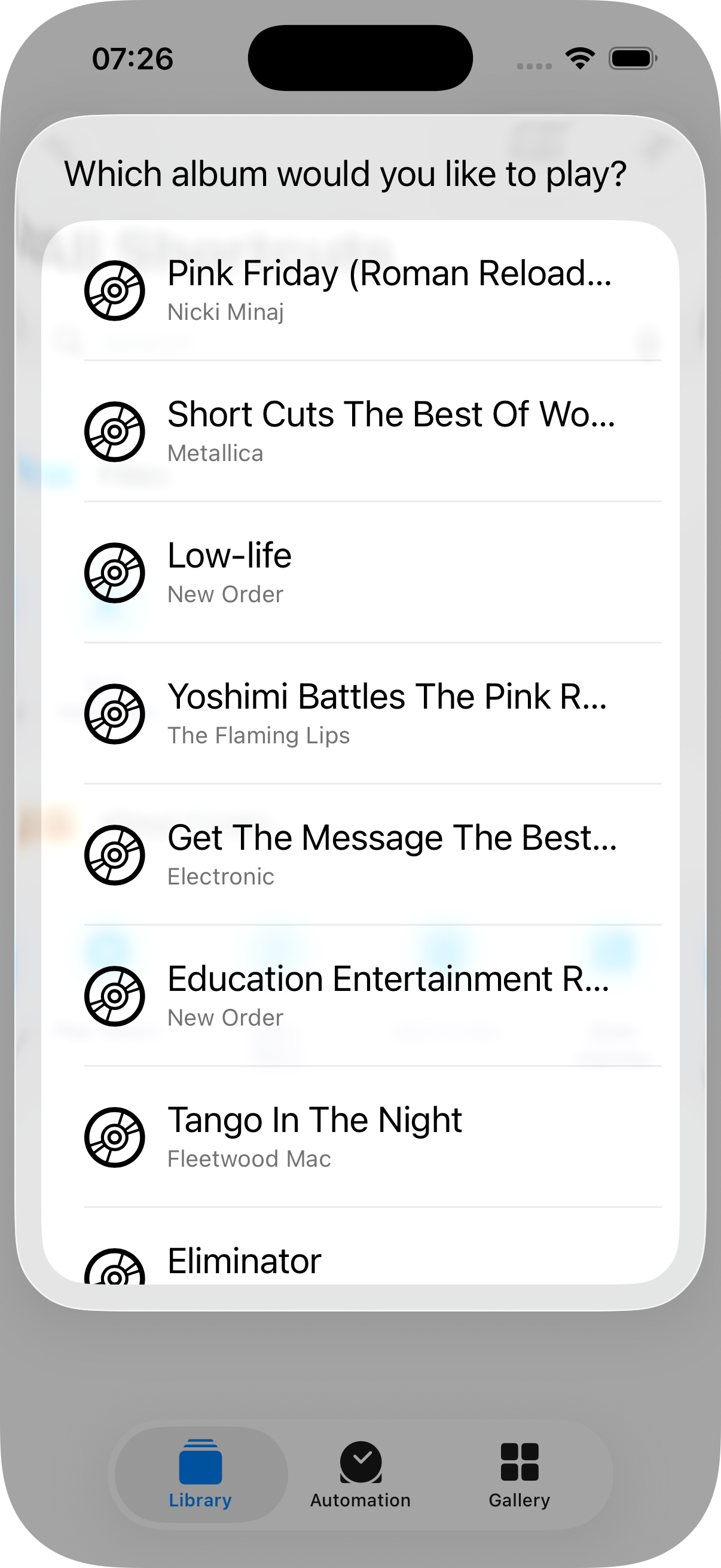 Siri disambiguation prompt 'Which album would you like to play?' with a list of albums from the user's collection — the result of @Parameter requestValueDialog firing after the Play Album tile is tapped without specifying an album