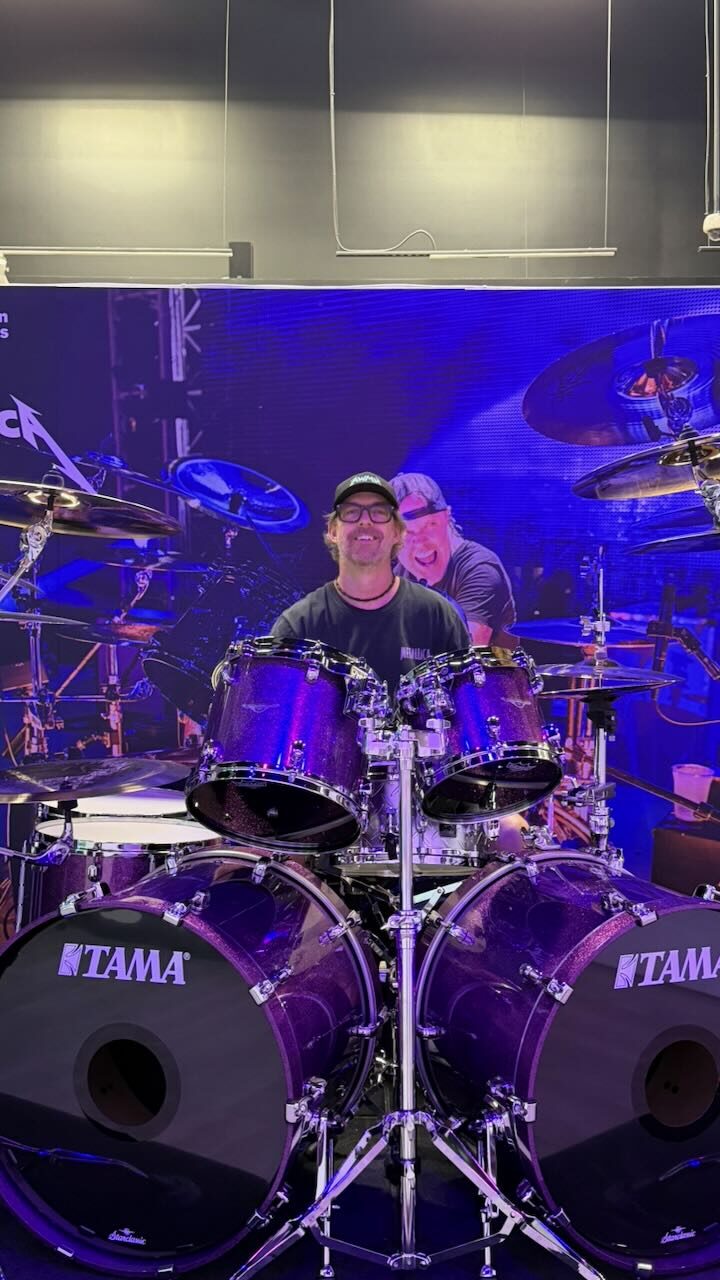 Wesley sitting behind a Tama drum kit at the blood drive photo op