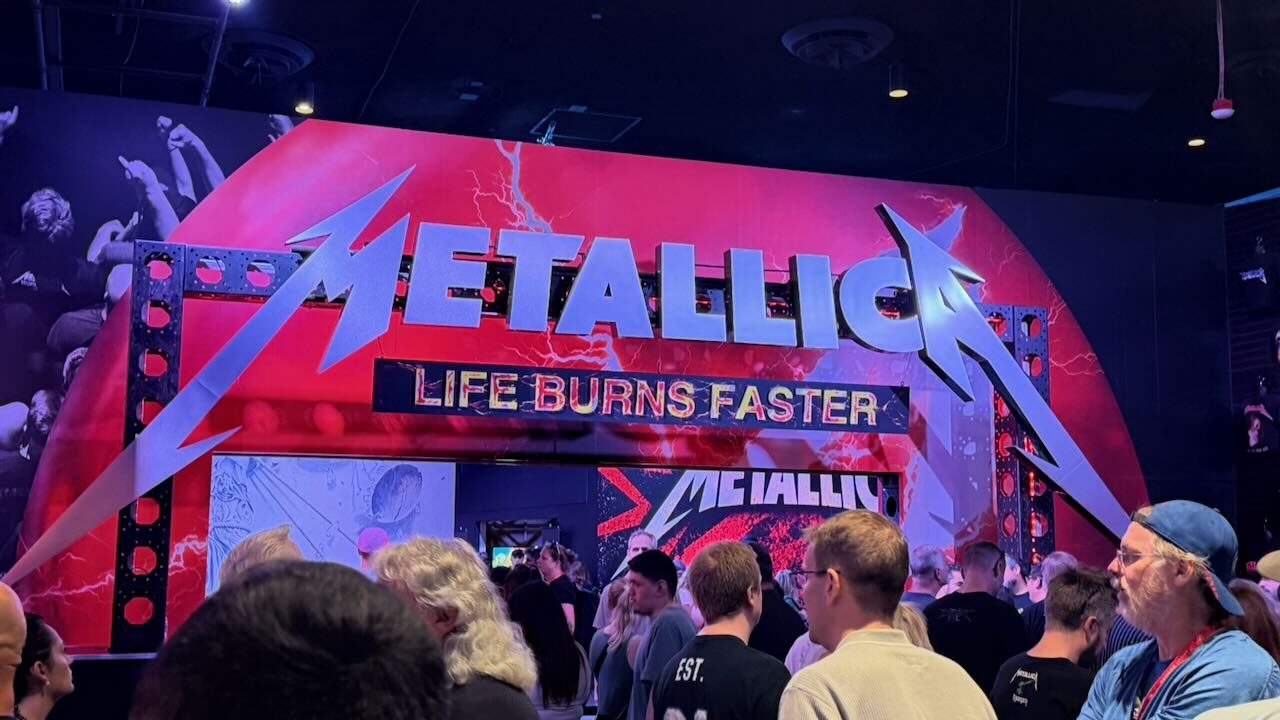 A large black arch reading METALLICA Life Burns Faster at the entrance to the fan zone outside the Sphere