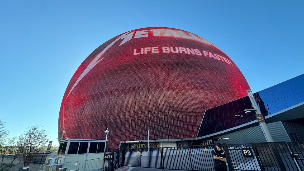 The Sphere in Las Vegas lit red with the Metallica logo and the words Life Burns Faster, under a clear blue sky