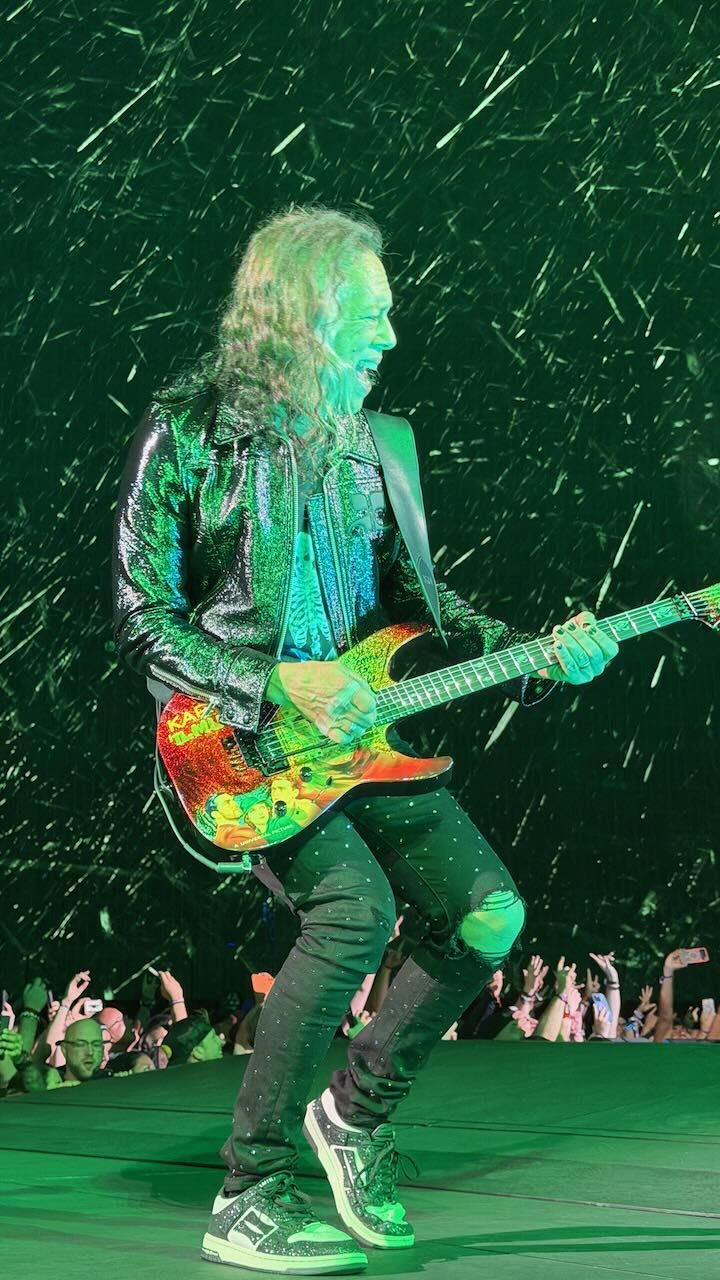 Kirk Hammett mid-solo on a green-lit stage