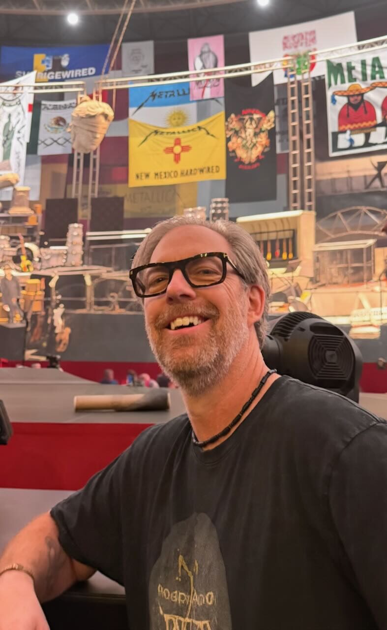 Wesley smiling on the rail on night two, with fan club flags on the screen behind him